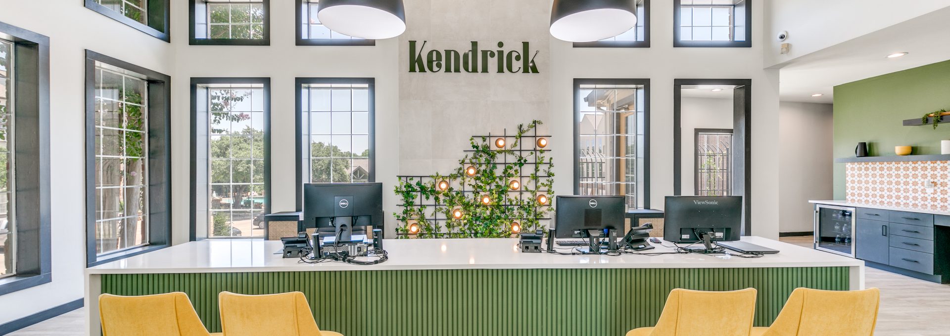 the lobby of a building with green chairs and yellow accents at The  Kendrick