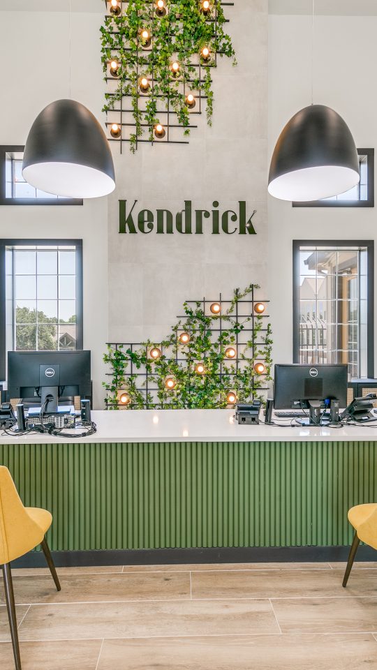 the lobby of a building with green chairs and yellow accents at The  Kendrick